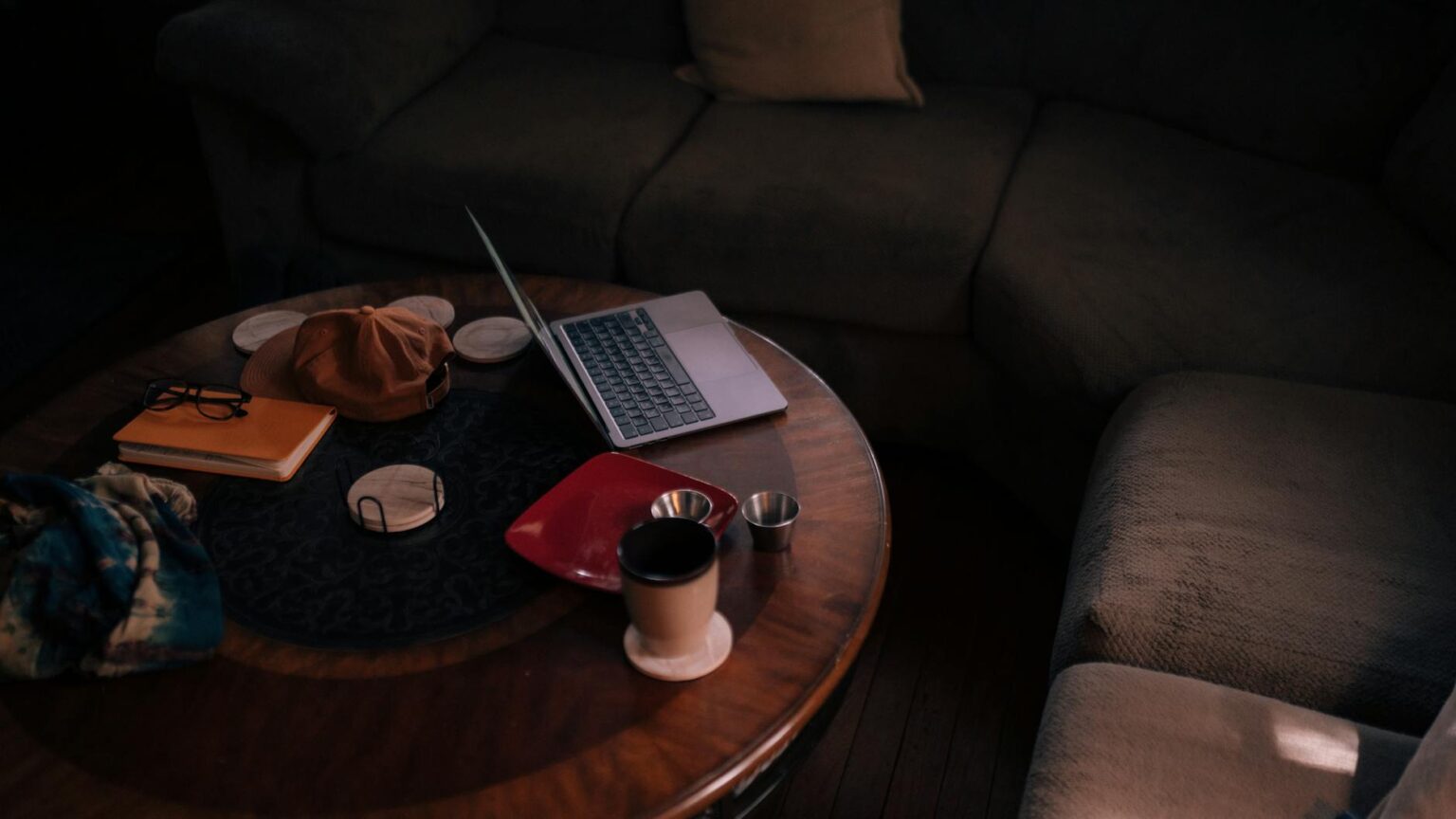 Freelancer working on laptop at coffee table representing independent gig work lifestyle