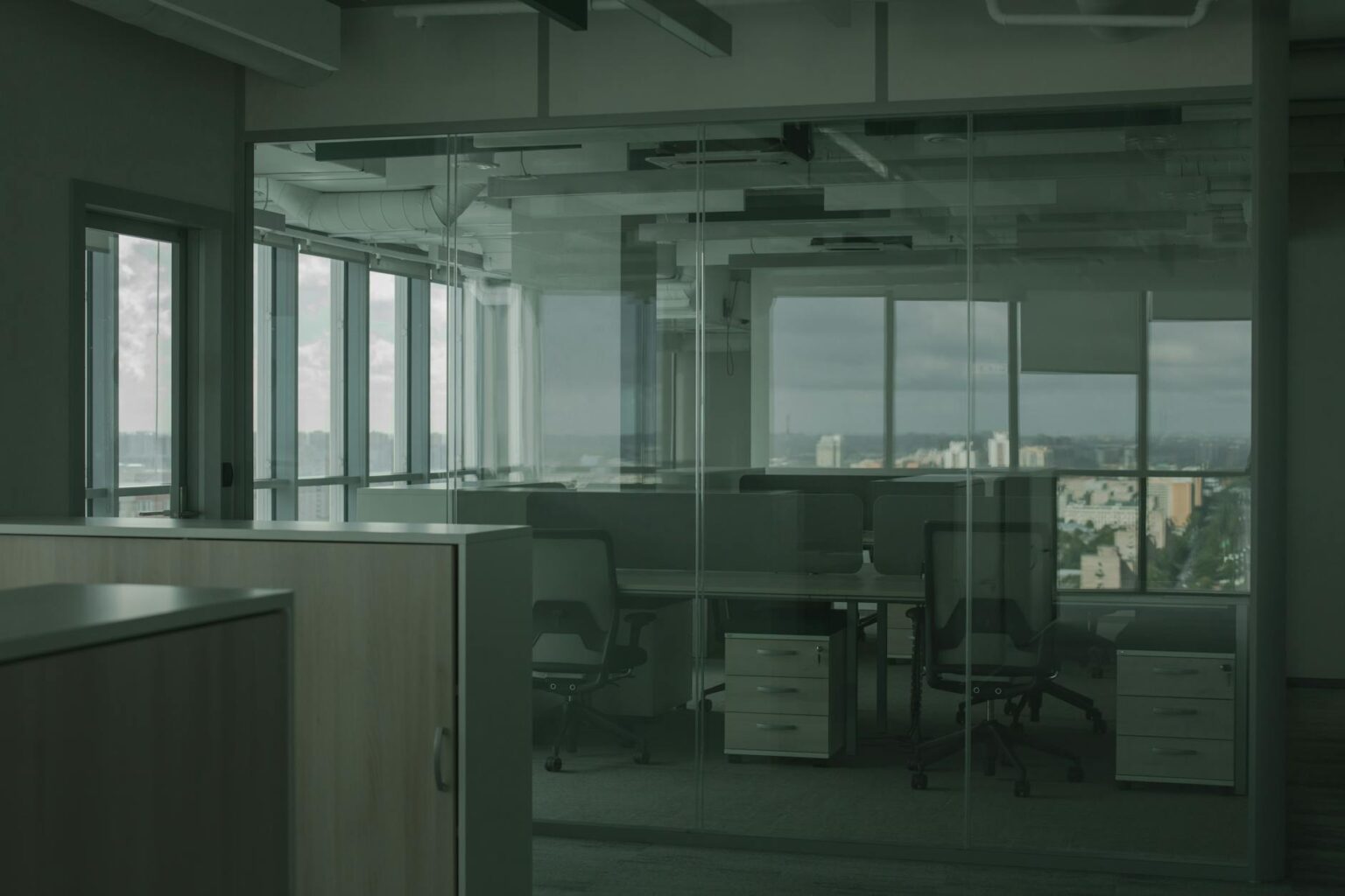 Empty office building interior with vacant cubicles and large windows