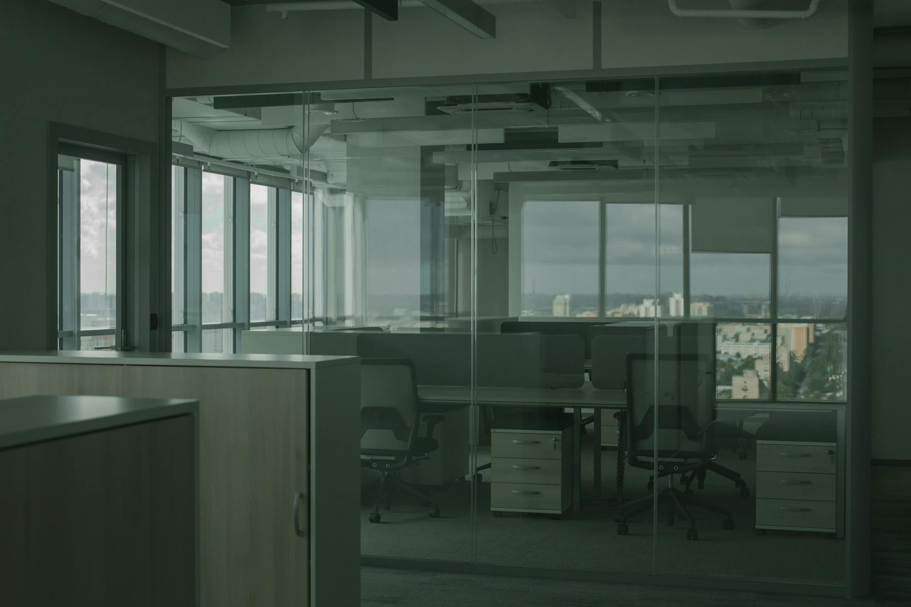 Empty office building interior with vacant cubicles and large windows