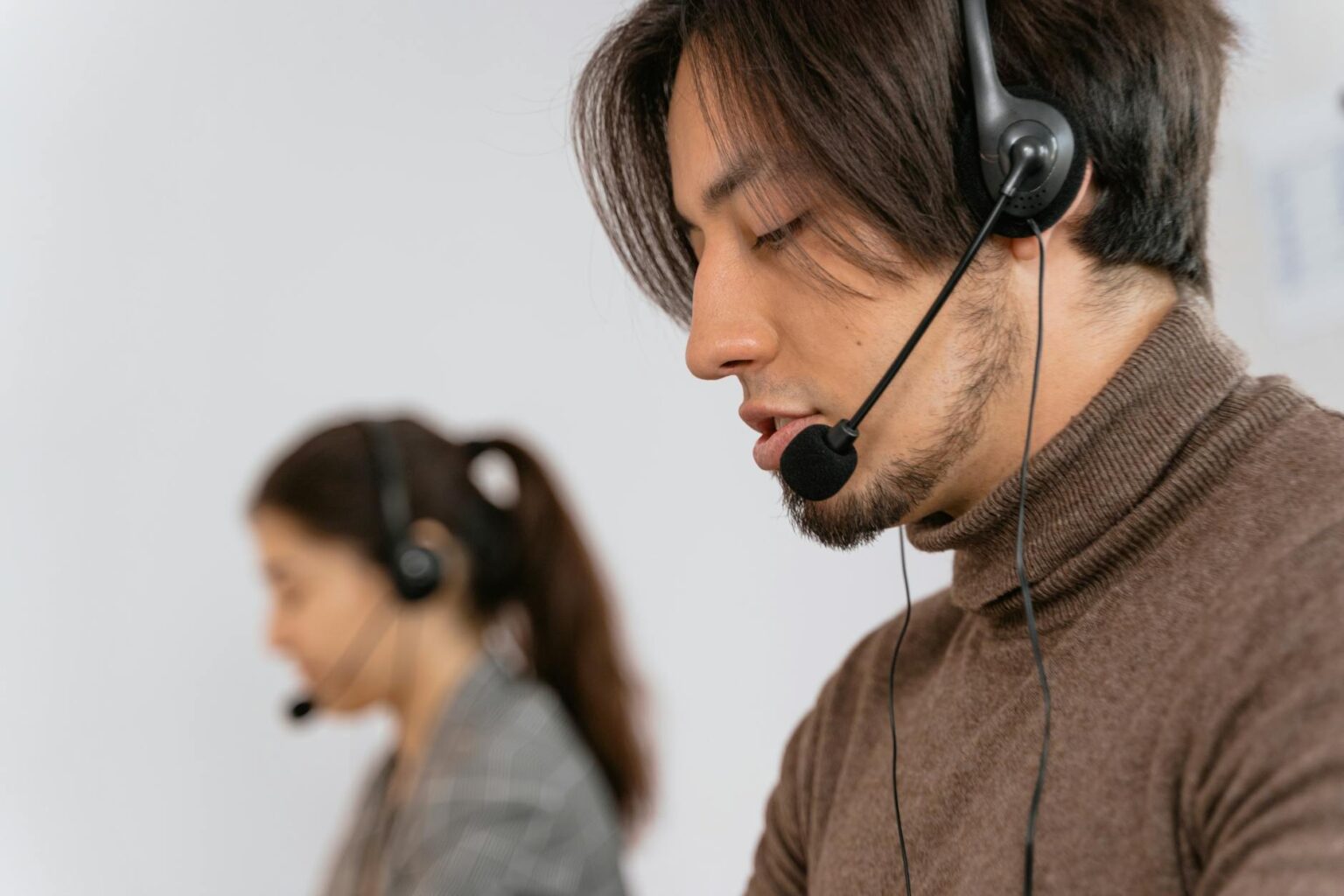 Customer service representative wearing headset at desk with computer