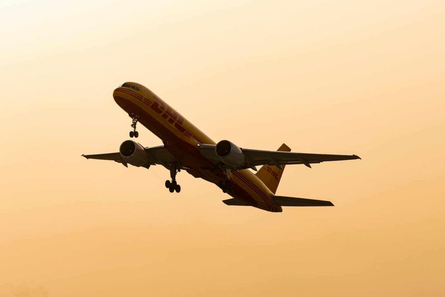Large cargo aircraft being loaded with packages at airport terminal