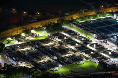 Modern water treatment facility with large circular clarifier tanks and industrial equipment