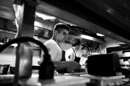 Restaurant kitchen workers preparing food during busy service period