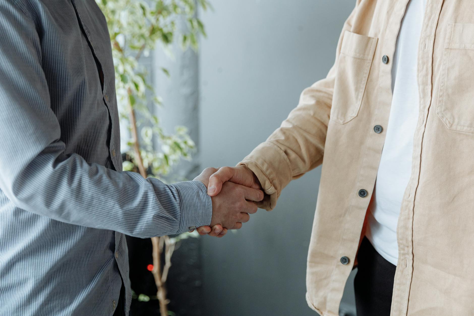 Professional business handshake between executives in suits representing merger agreement