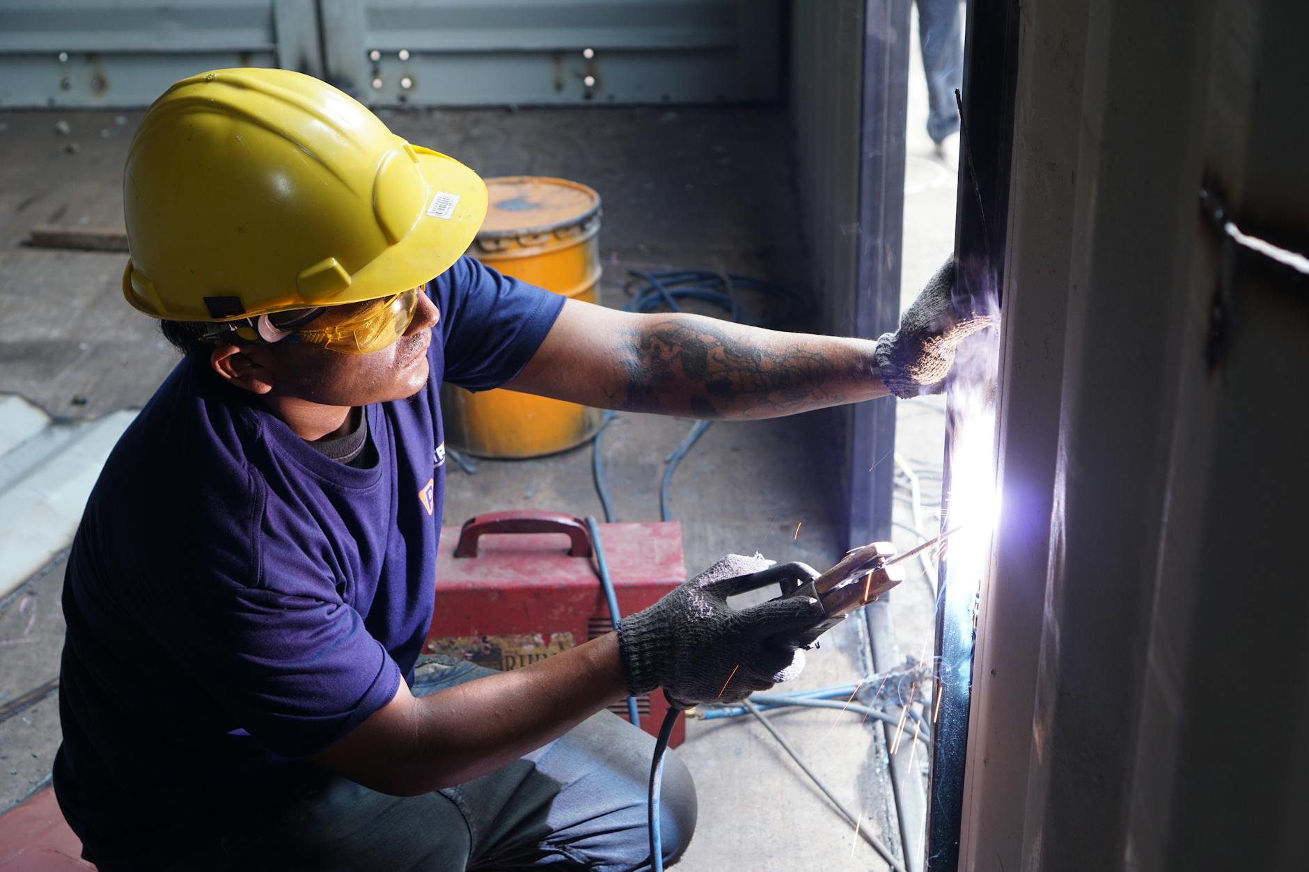 Skilled manufacturing worker operating welding equipment in industrial setting