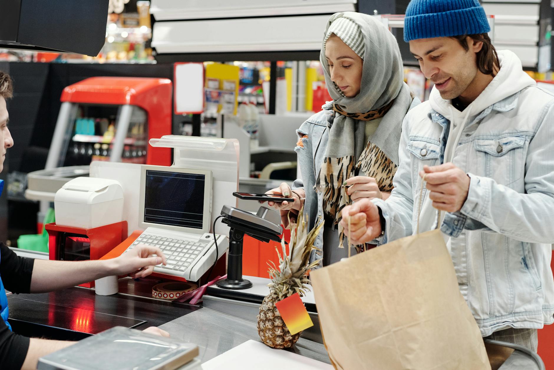 Customer using self-checkout terminal at retail store with digital interface and scanner