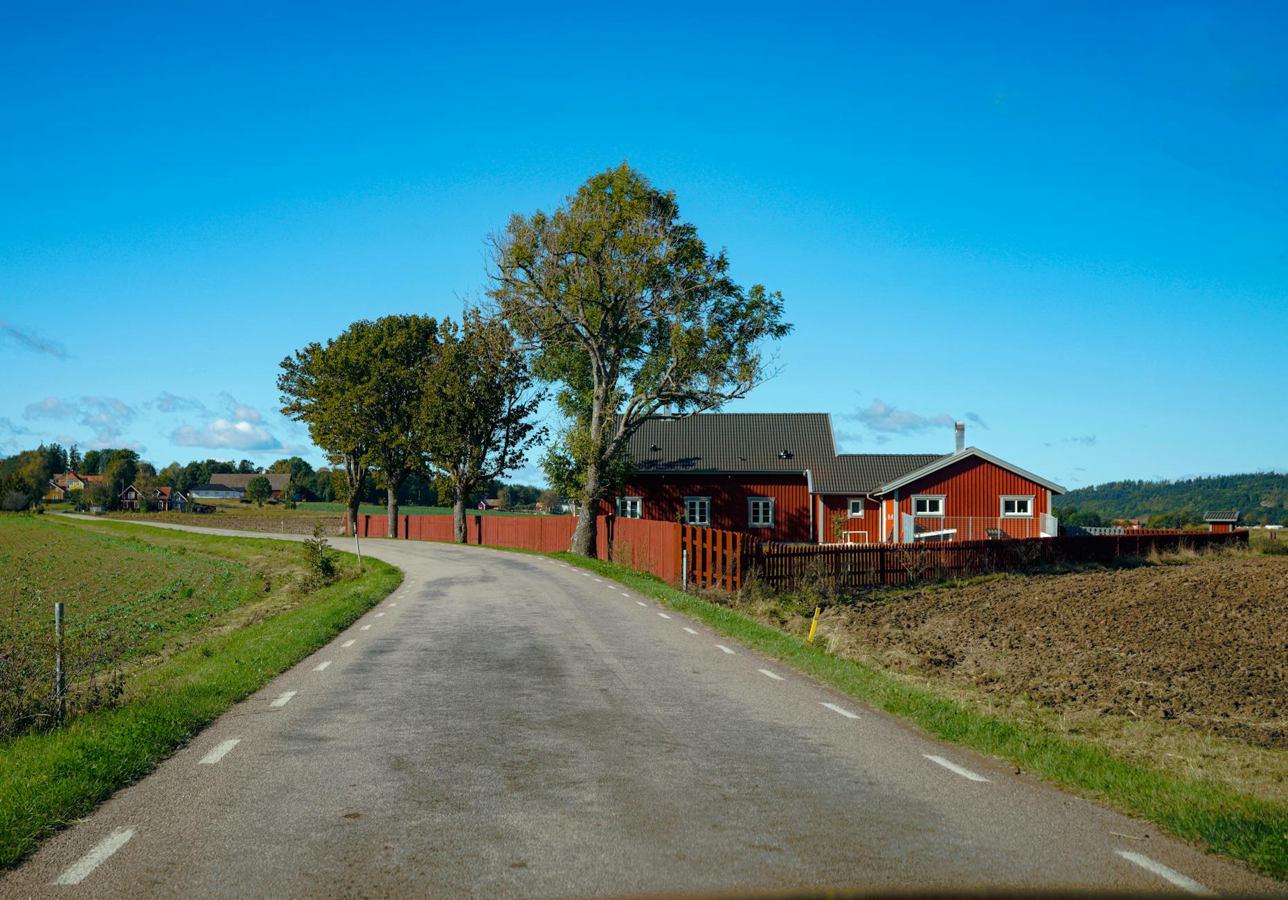 Empty rural road stretching into the distance through countryside landscape