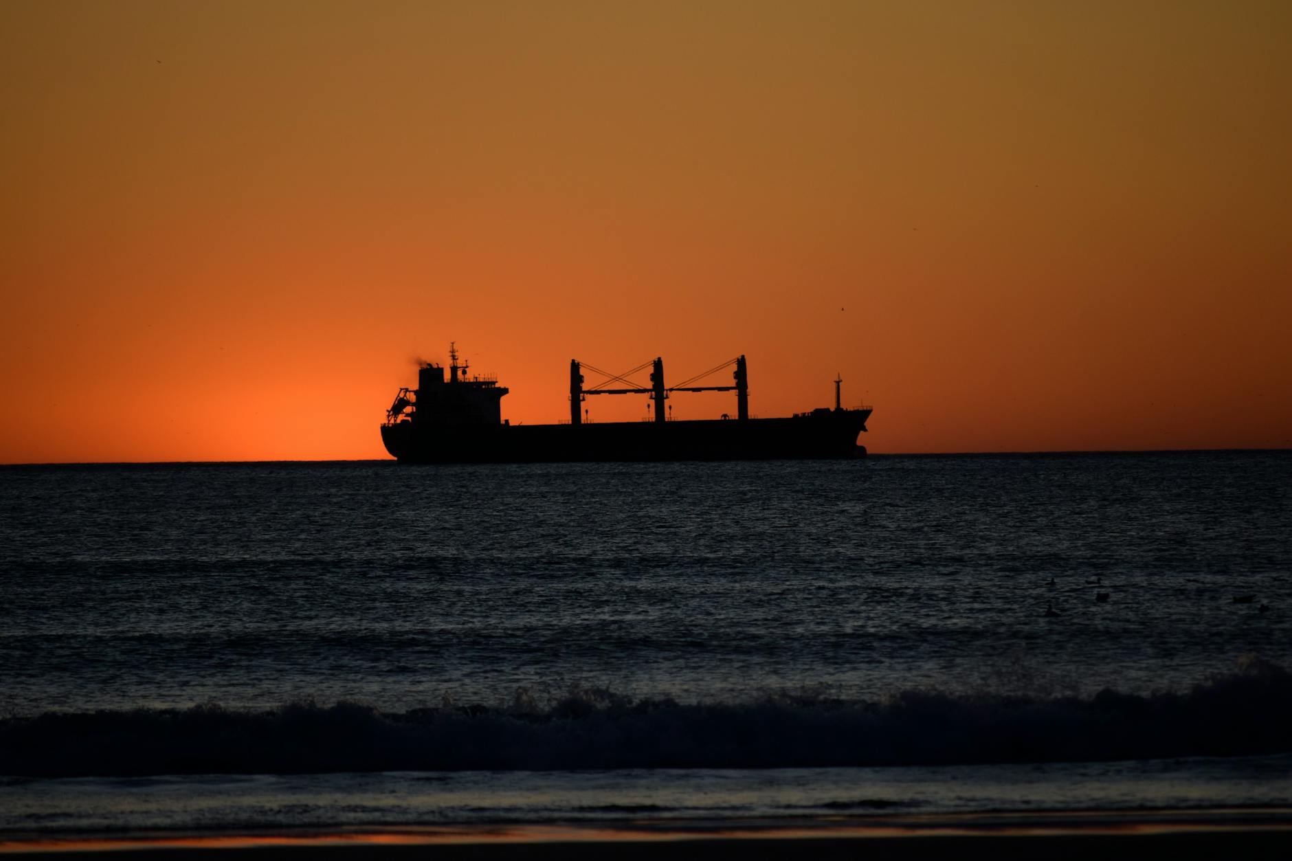 Container ship sailing on open ocean under blue sky