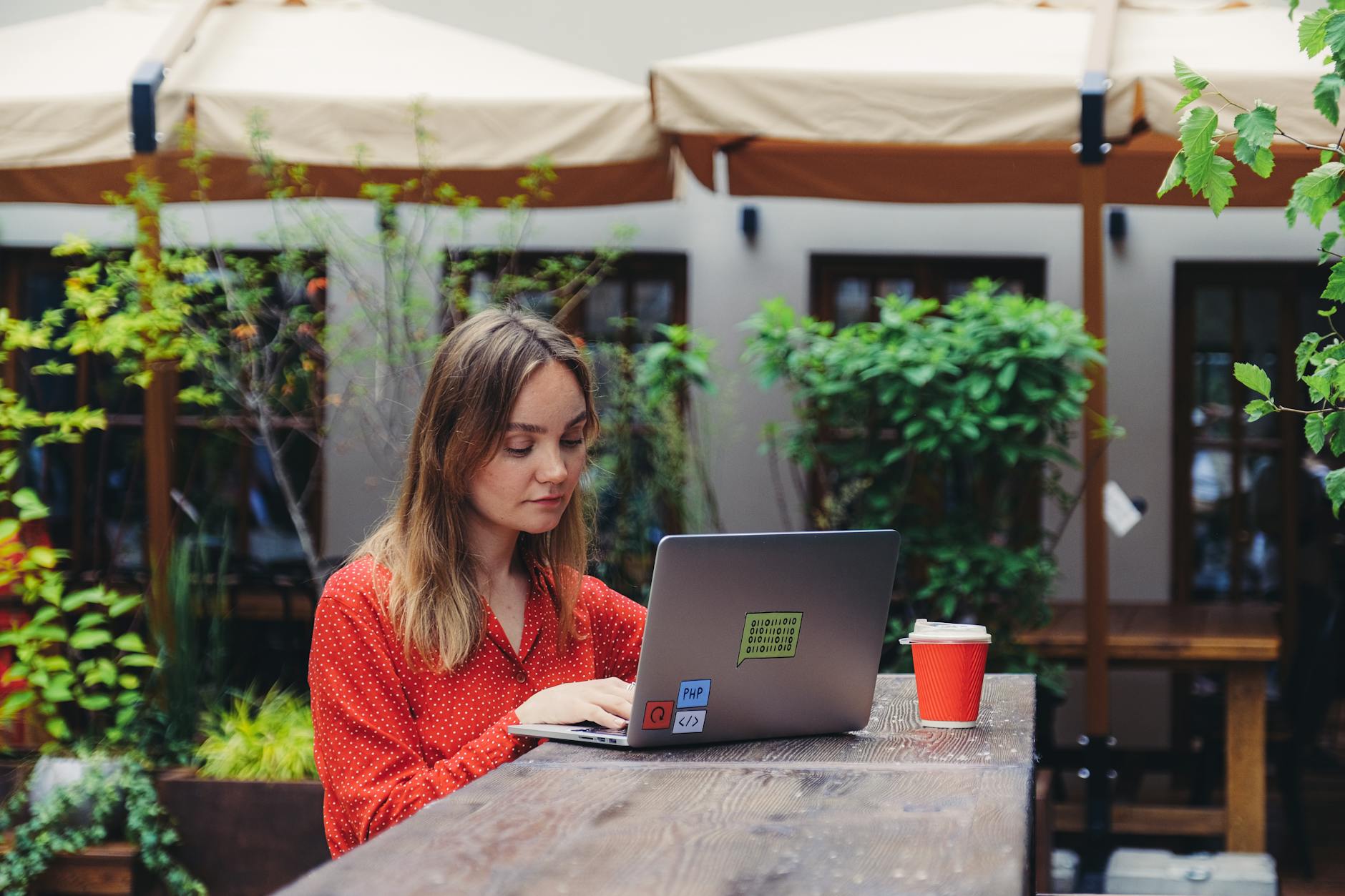 Person working remotely on laptop in a cozy local coffee shop setting