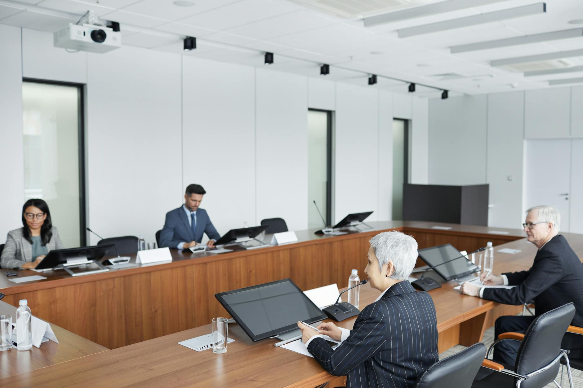 Professional business meeting in modern boardroom with executives discussing strategy
