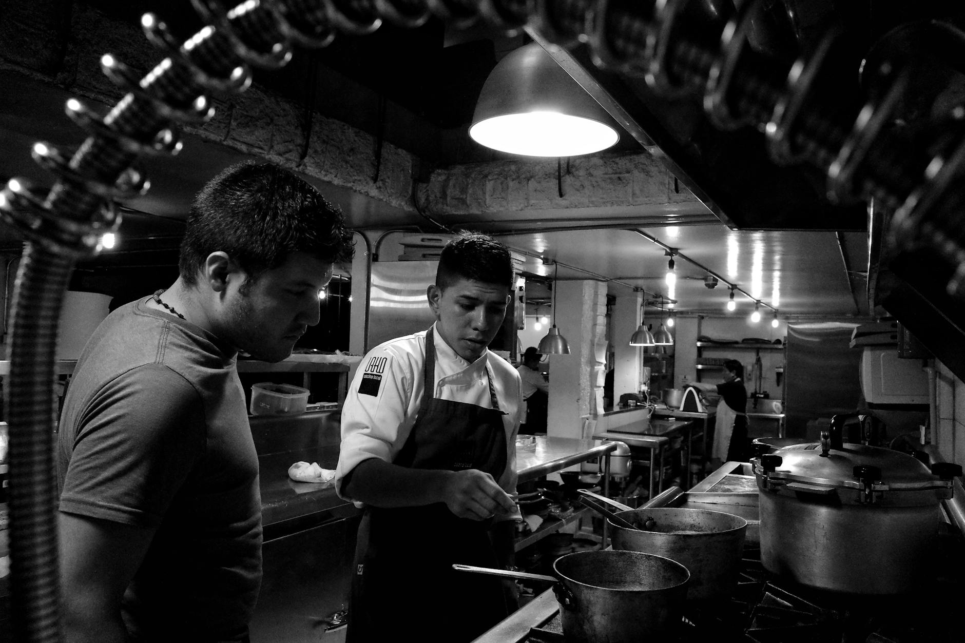 Busy restaurant kitchen with chefs preparing multiple food orders