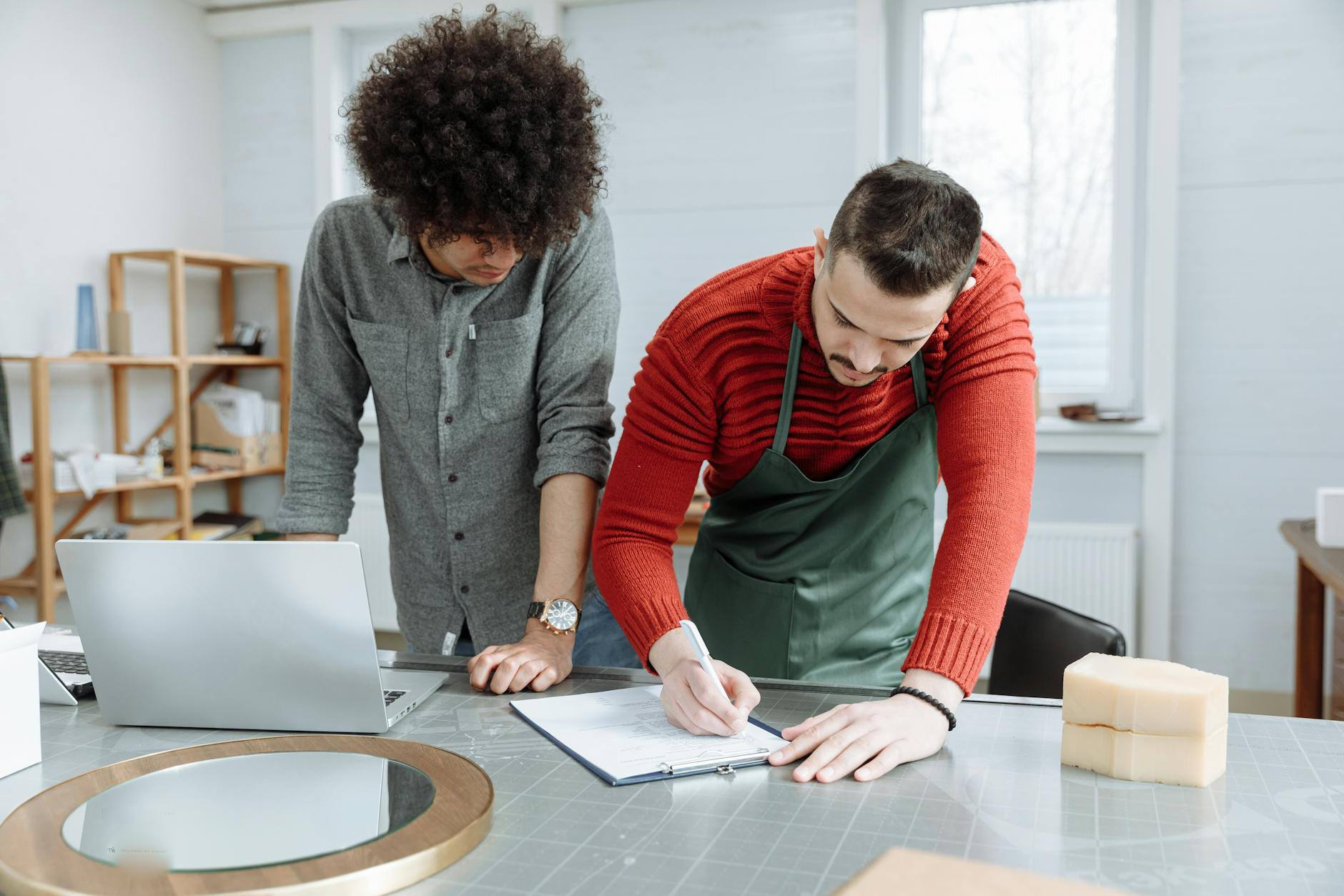 Small business owner working at desk with laptop and paperwork