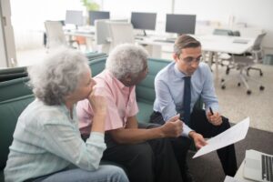 Business professionals reviewing pension and retirement plan documents in a corporate office setting