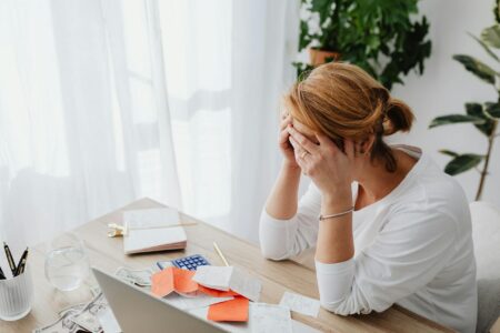 Young adult reviewing financial documents with a concerned expression