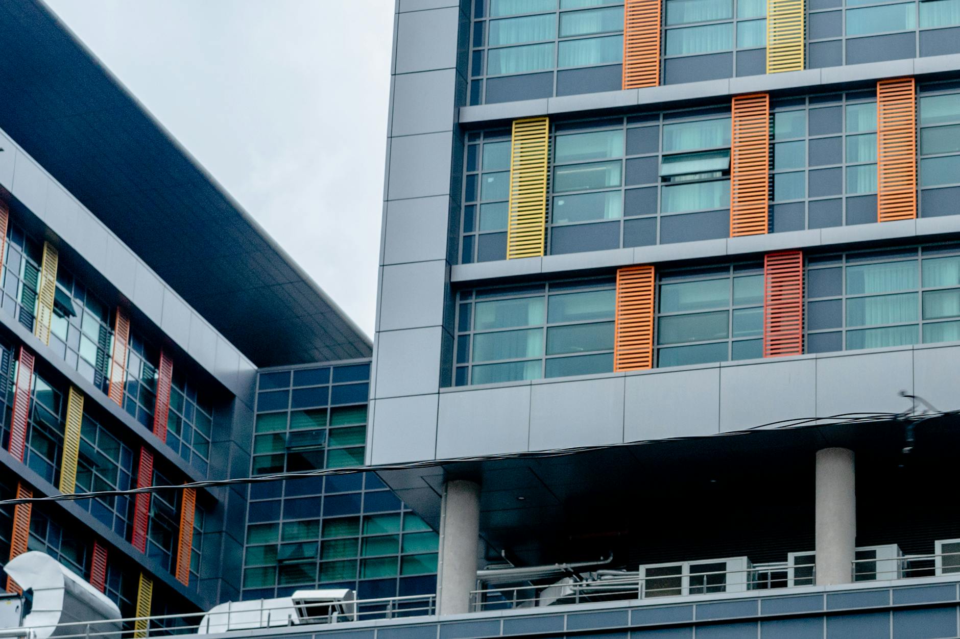 Modern office building exterior with glass windows reflecting empty floors