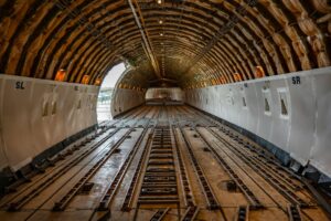 Major Airlines Convert Unused Aircraft Into Cargo-Only Operations Interior view of aircraft cargo compartment with freight containers and loading equipment