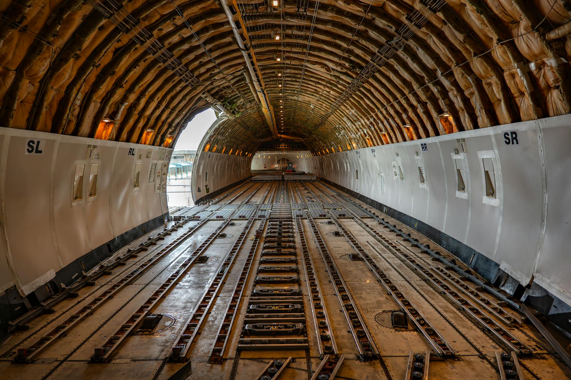 Interior view of aircraft cargo compartment with freight containers and loading equipment