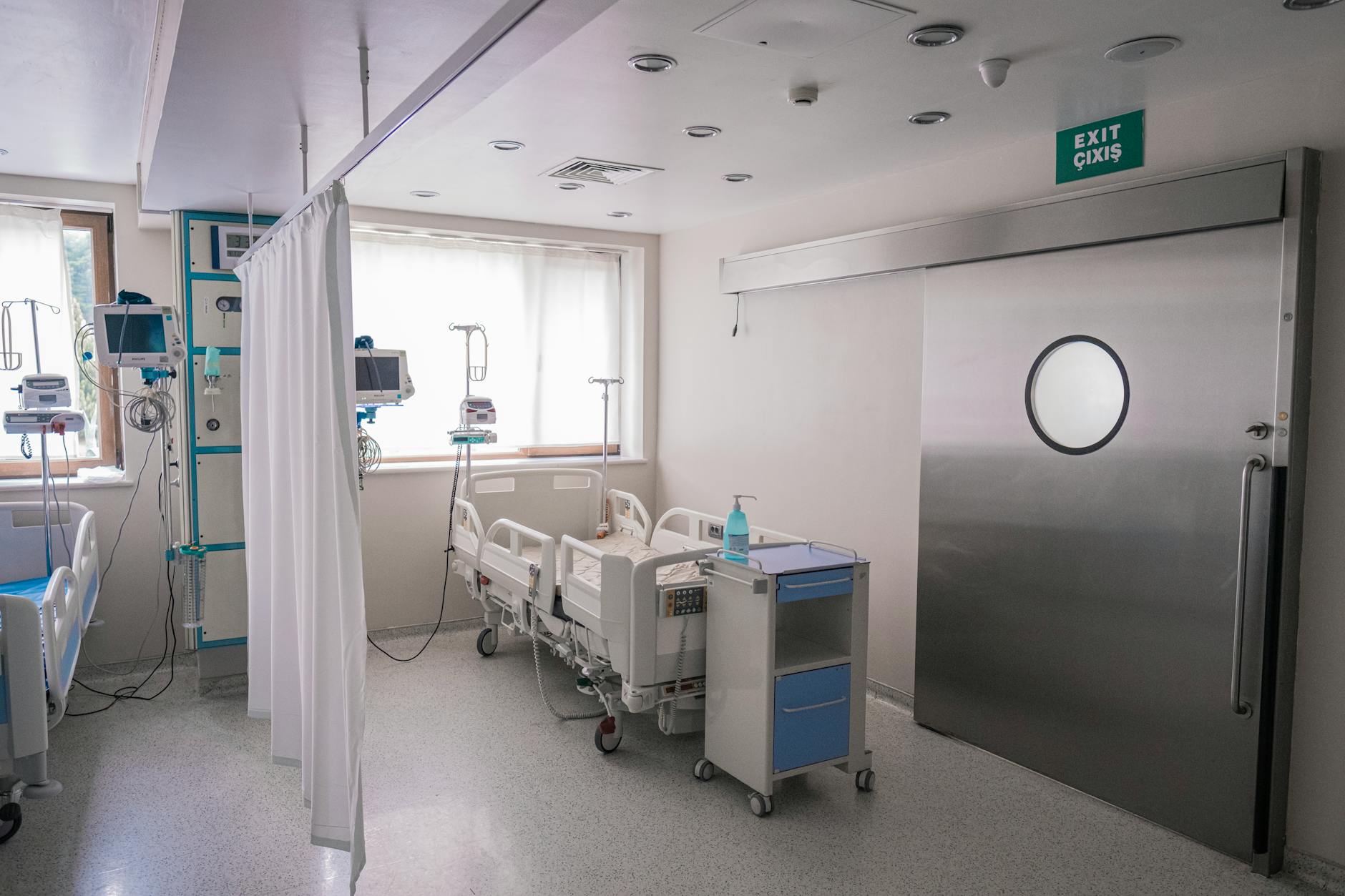 Empty hospital hallway with fluorescent lighting and closed doors