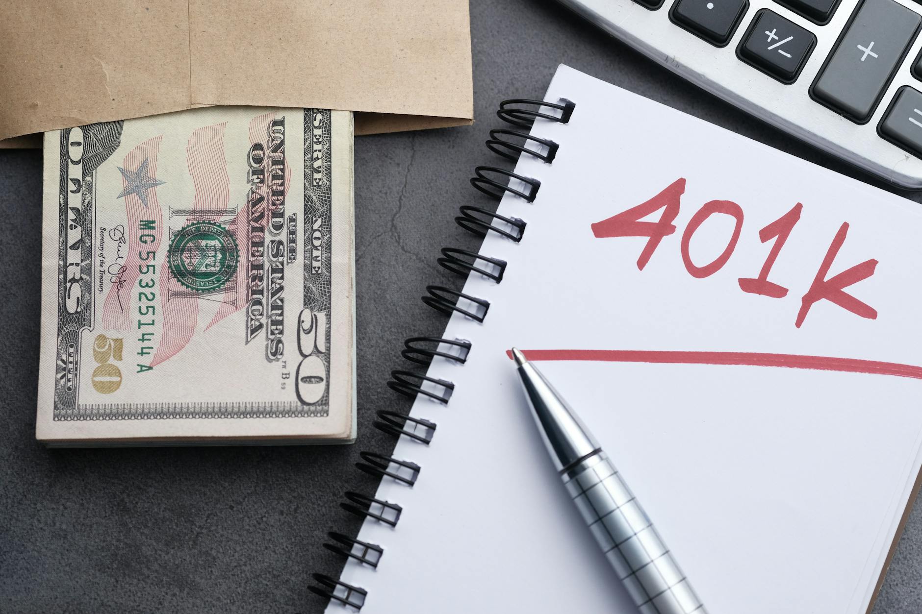 A person reviewing retirement savings documents and financial planning materials at a desk