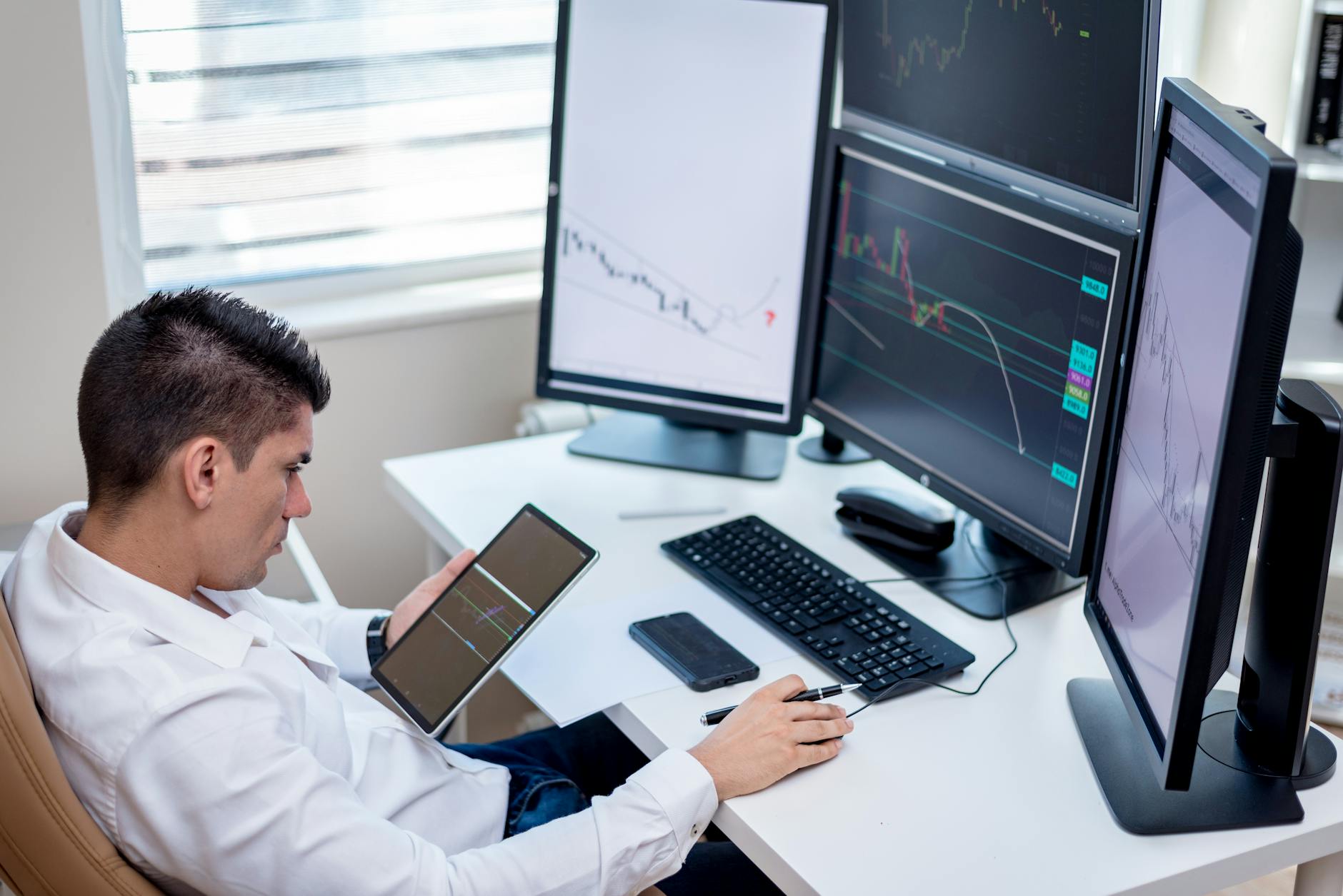 Investor reviewing financial data at a desk with charts and reports