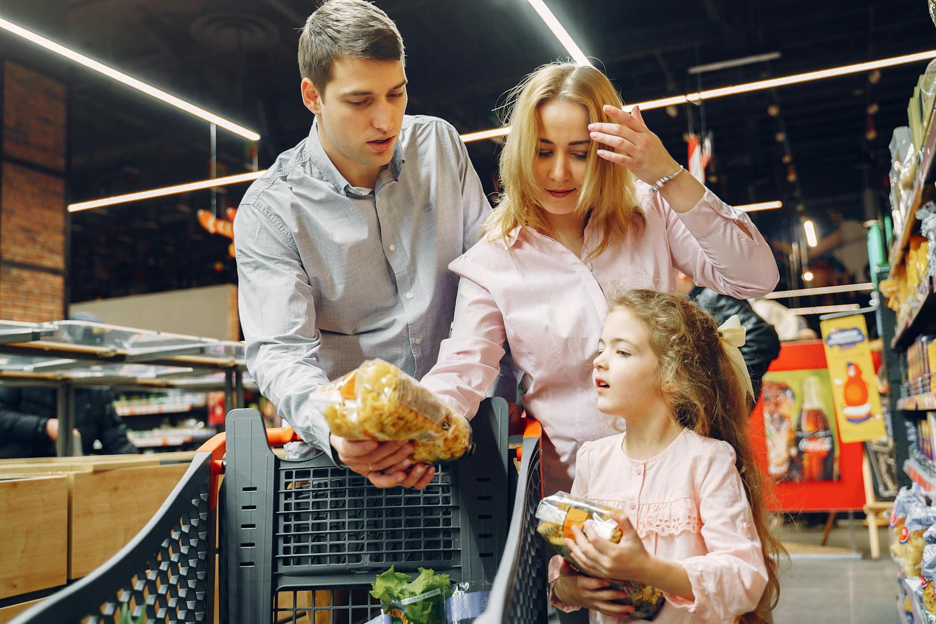Family pushing a grocery cart through a store, representing households managing tight food budgets