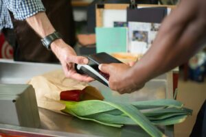 Shopper scanning loyalty card at grocery store checkout counter