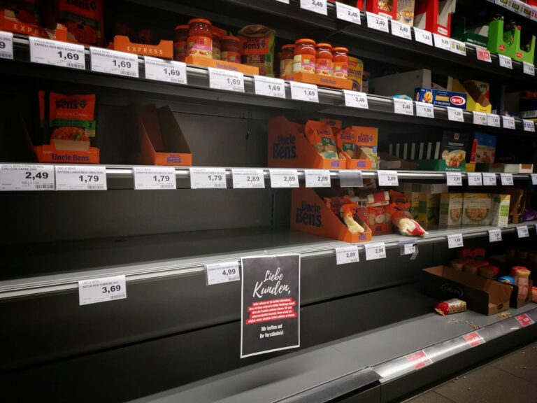 Empty shelves inside a closed grocery store in an urban neighborhood