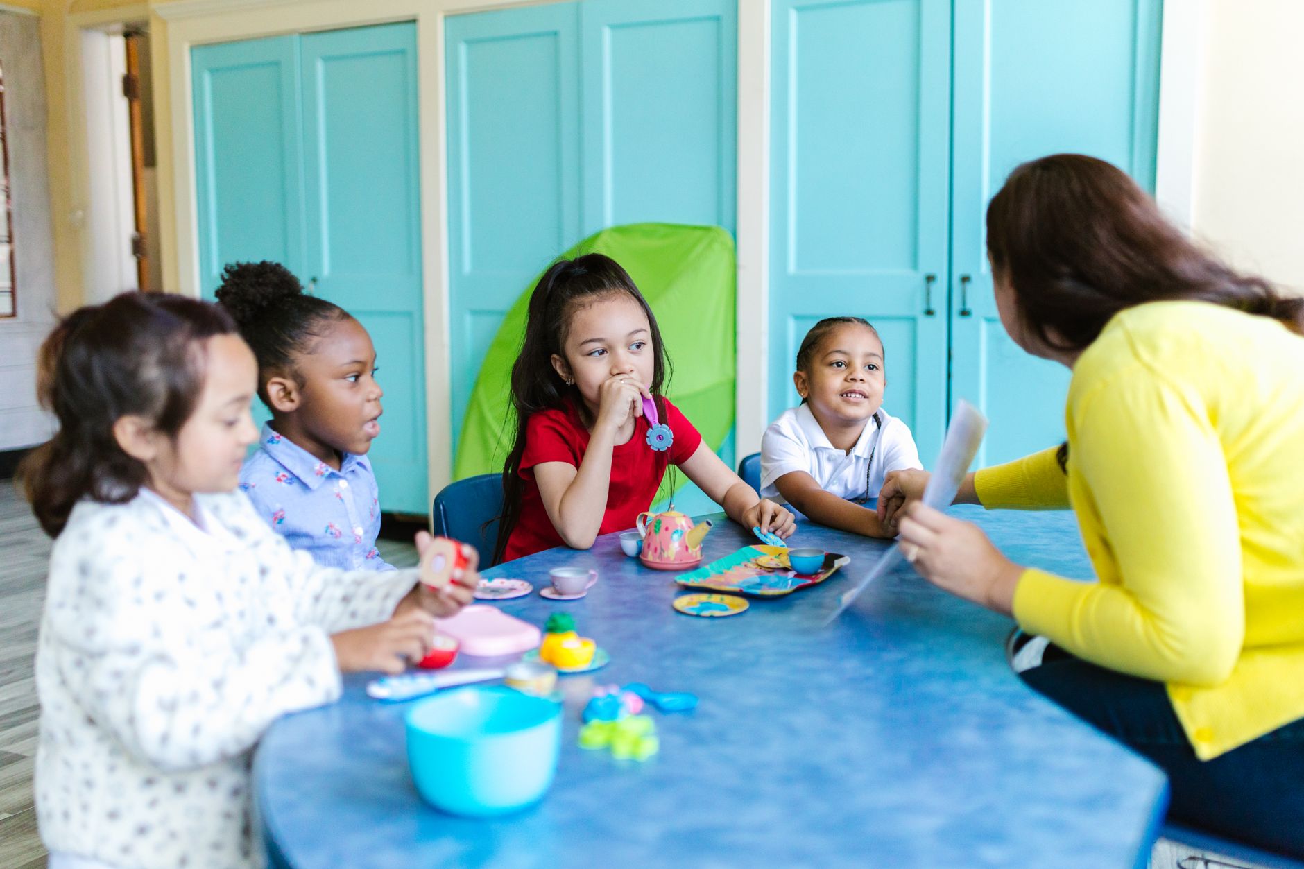 Children sitting at tables in a licensed childcare center classroom