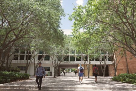 Students walking across a college campus, representing the population Pell Grants are designed to support