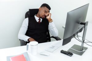 Tired salaried office worker sitting at desk after long hours