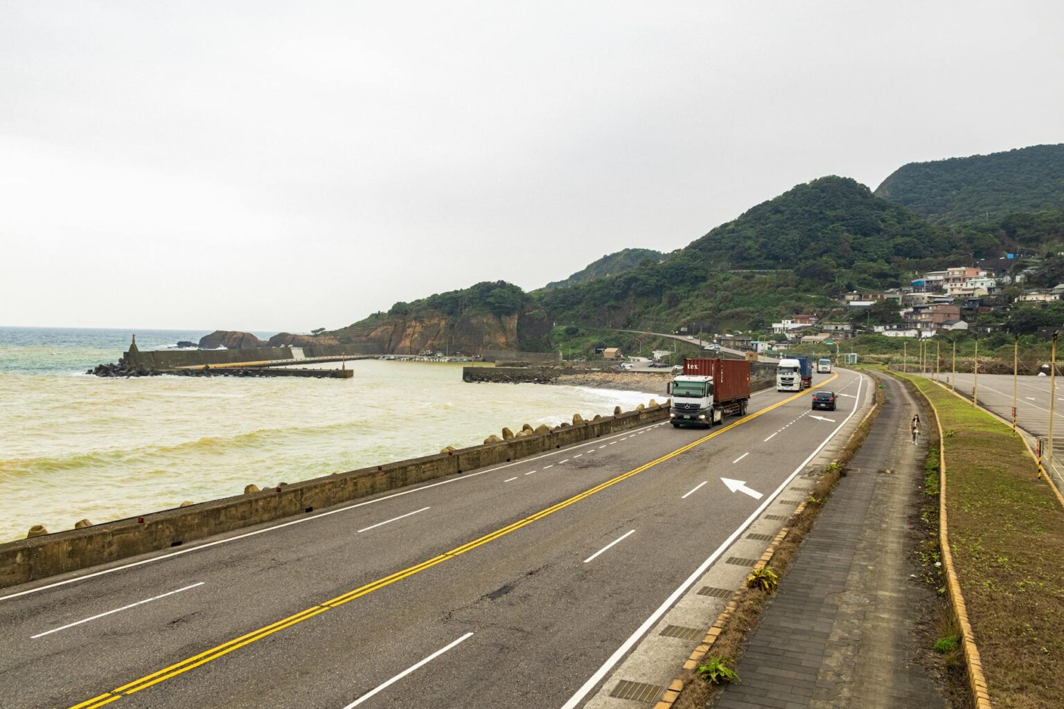 Multiple freight trucks driving on a highway representing supply chain logistics