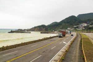 Multiple freight trucks driving on a highway representing supply chain logistics
