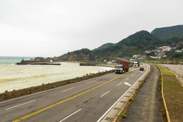 Multiple freight trucks driving on a highway representing supply chain logistics