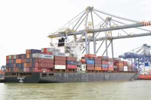 Large cargo containers stacked at a busy commercial port terminal