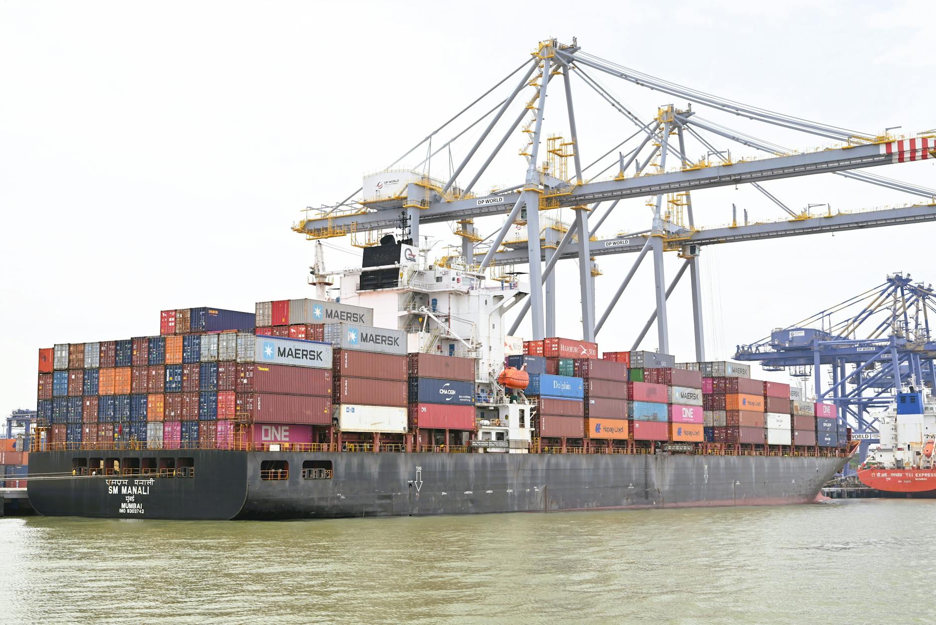 Large cargo containers stacked at a busy commercial port terminal
