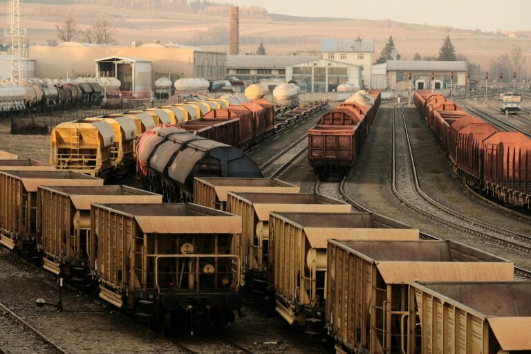 Aerial view of a busy freight rail yard with stacked shipping containers