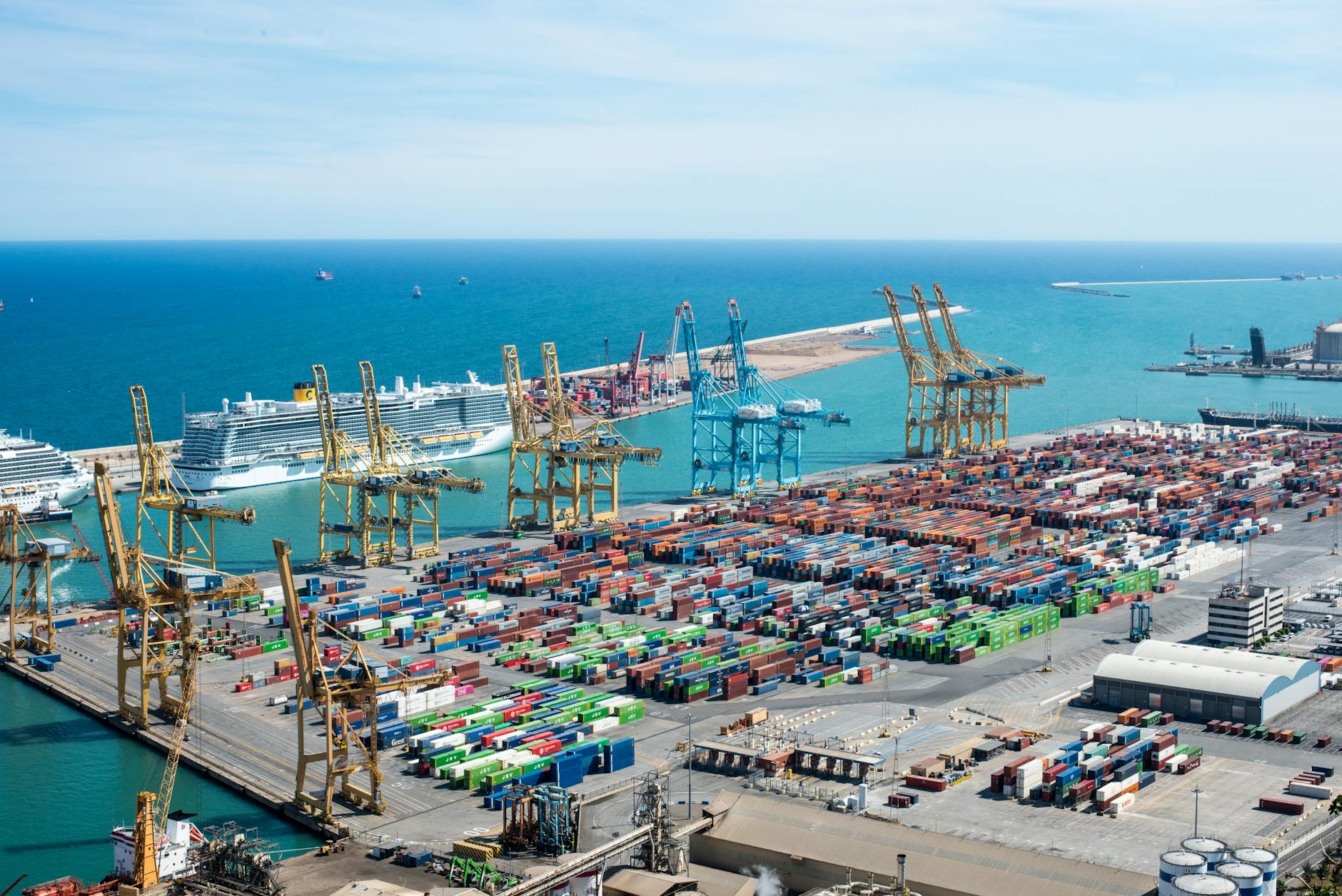 Aerial view of a busy container port with stacked shipping containers and cranes