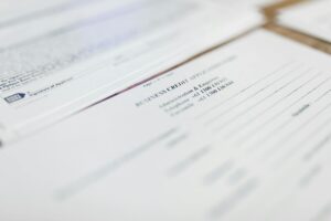 Person reviewing health insurance enrollment paperwork at a desk