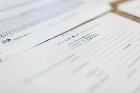 Person reviewing health insurance enrollment paperwork at a desk