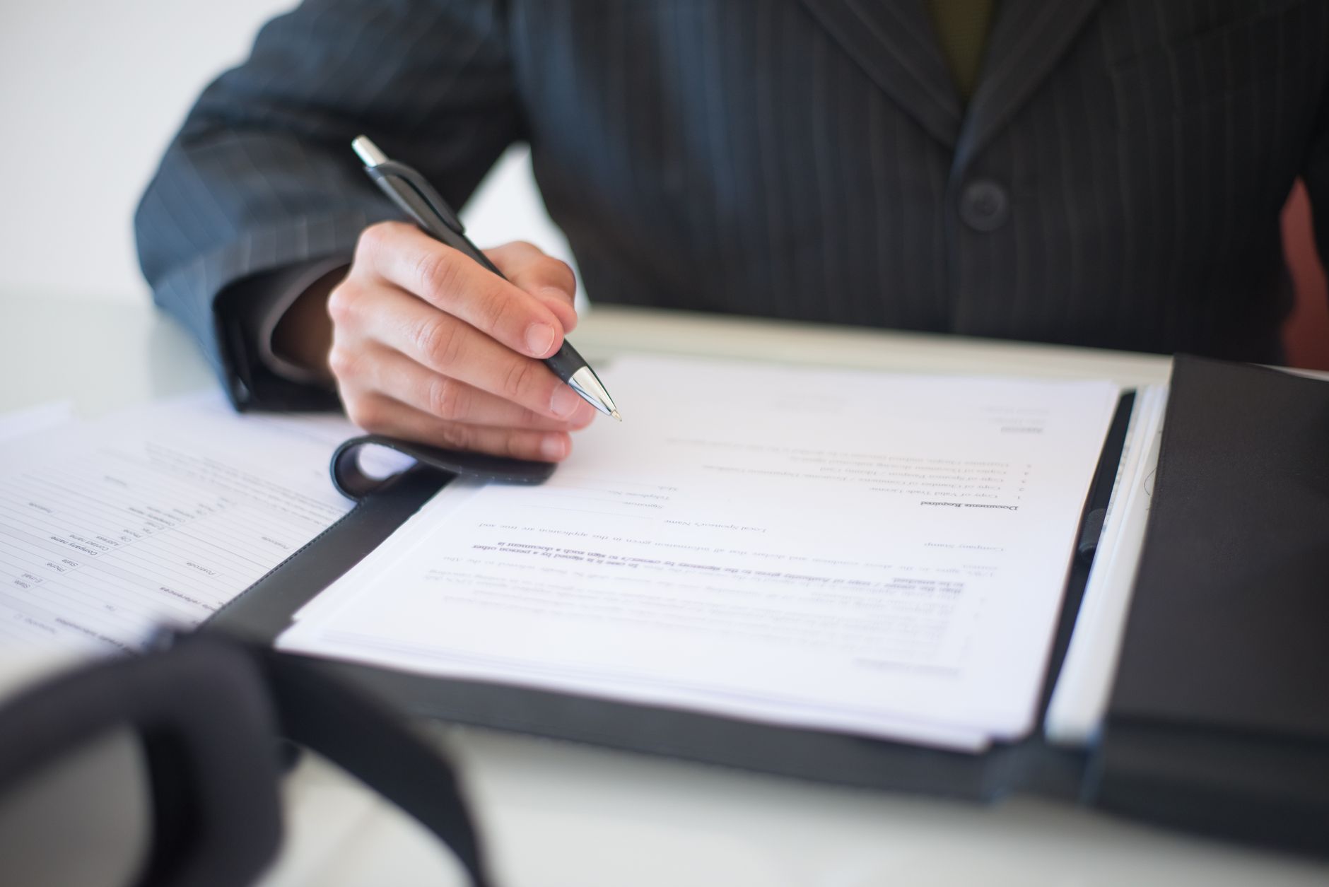 Auto loan paperwork and pen on a desk in a lender's office