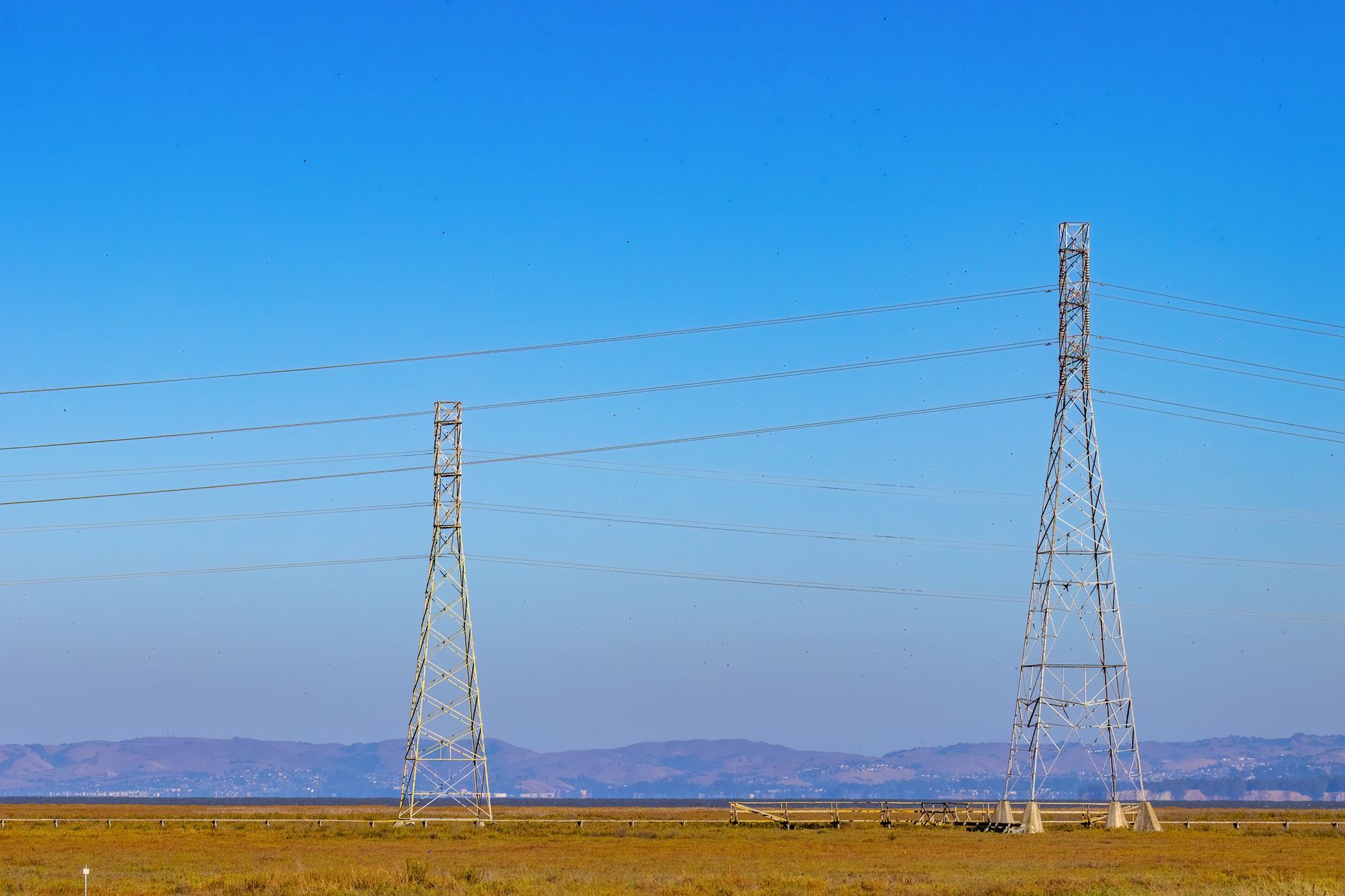 High-voltage electrical transmission towers against a clear sky