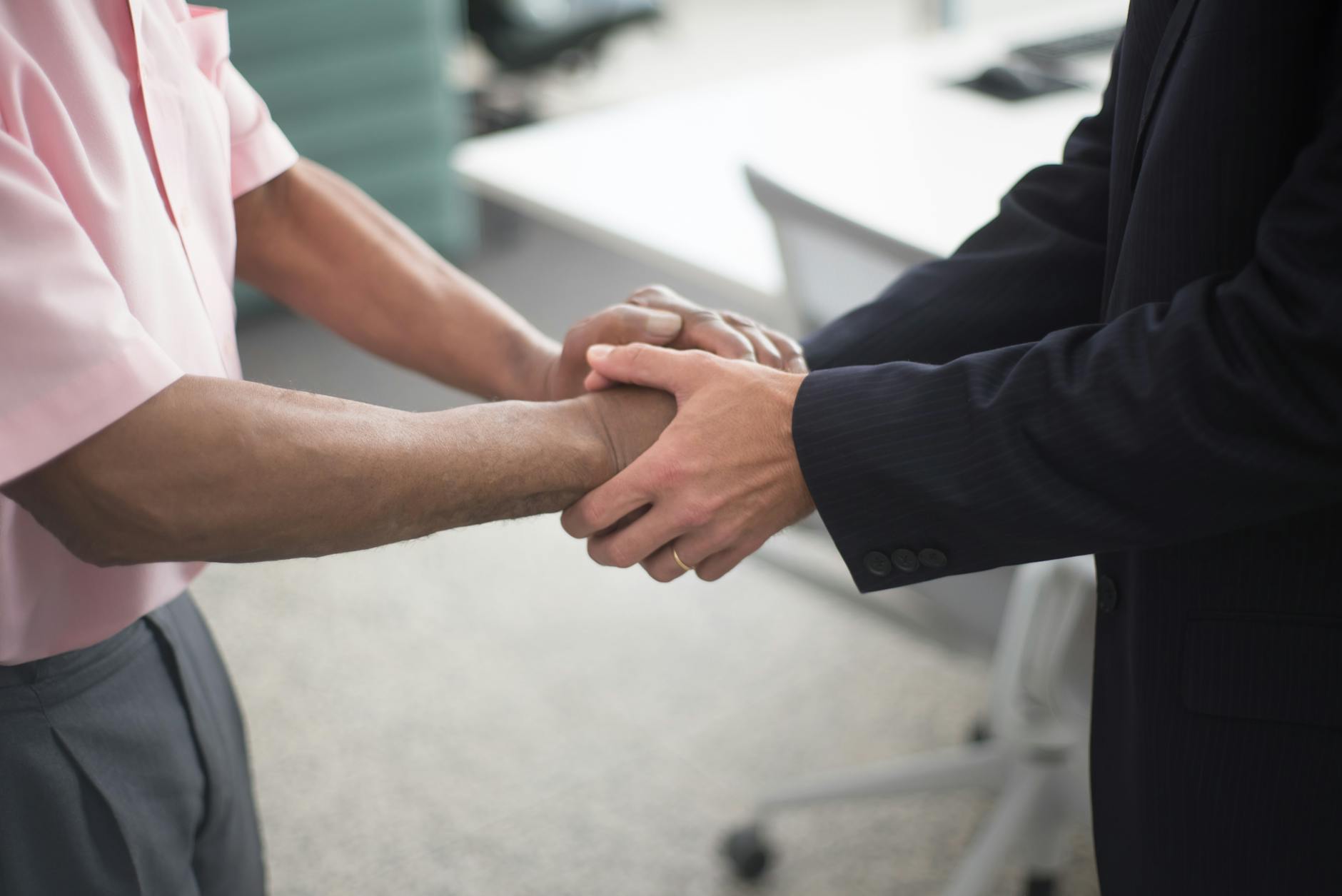 Two business professionals shaking hands representing a corporate acquisition deal