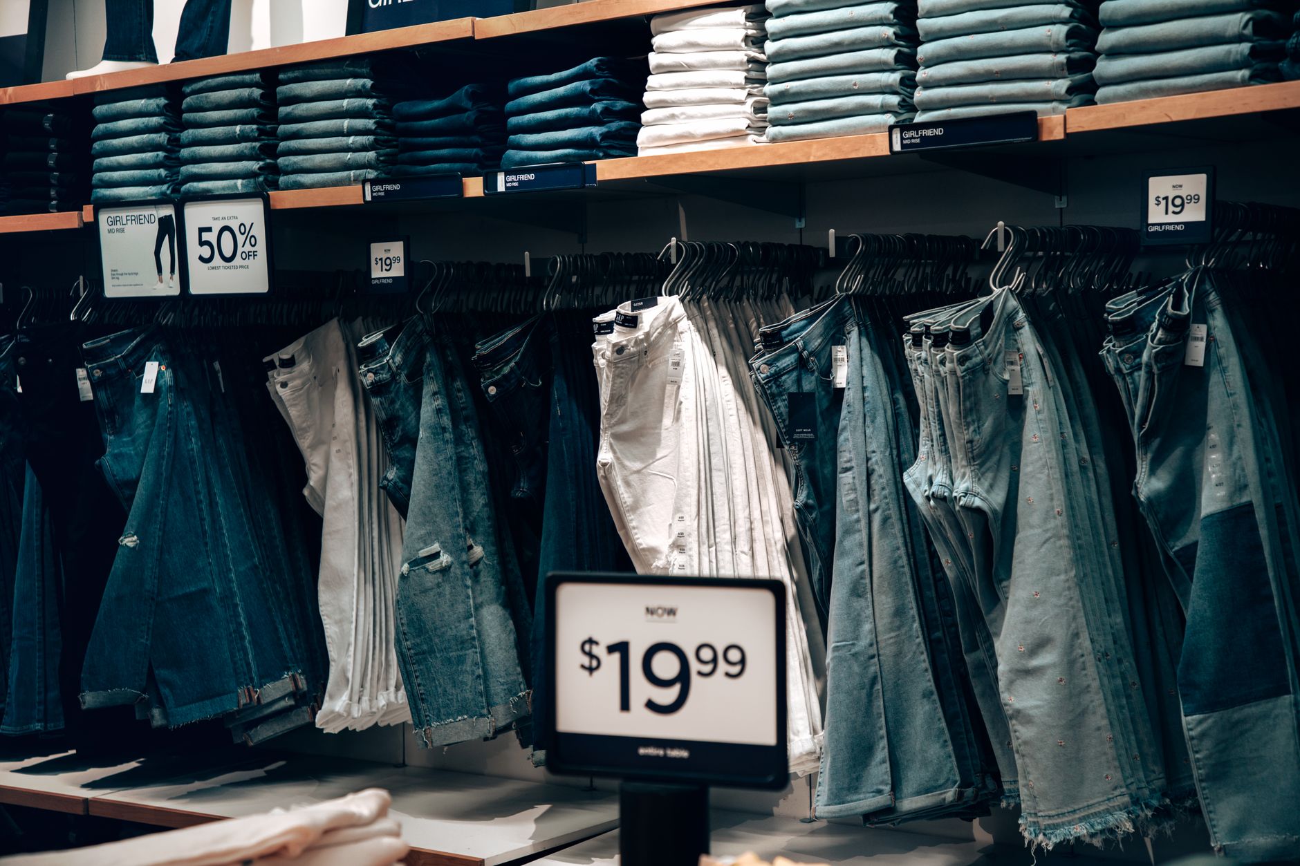 Discounted clothing racks inside a retail store during a clearance sale