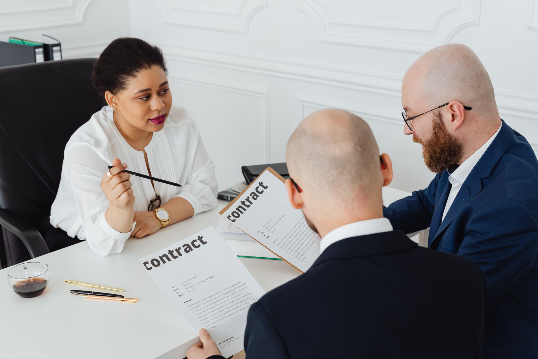 Two people reviewing and signing a business contract representing hospital vendor agreements