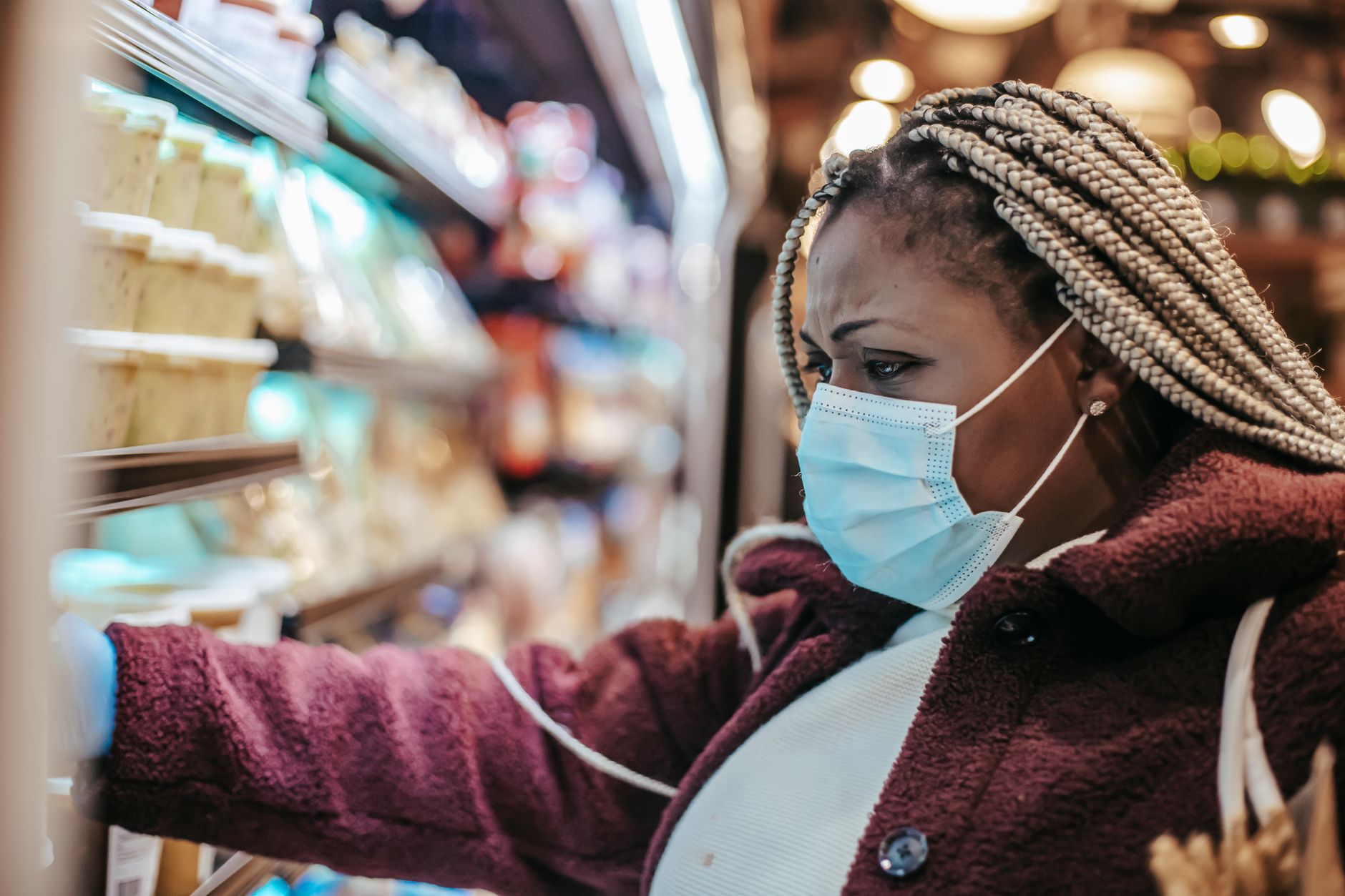 A shopper examining products in a grocery store aisle