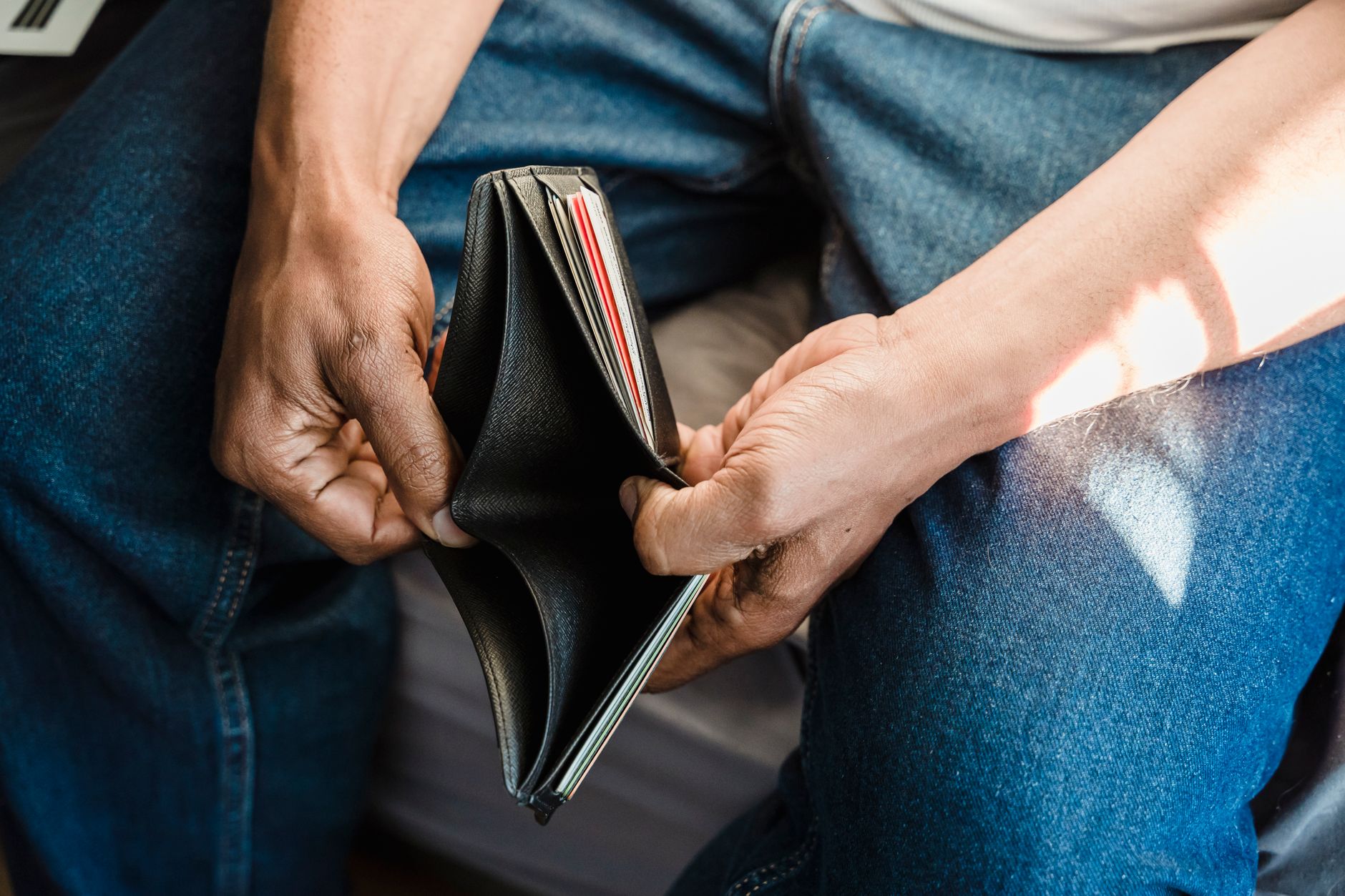 Open wallet with no cash visible, symbolizing financial hardship