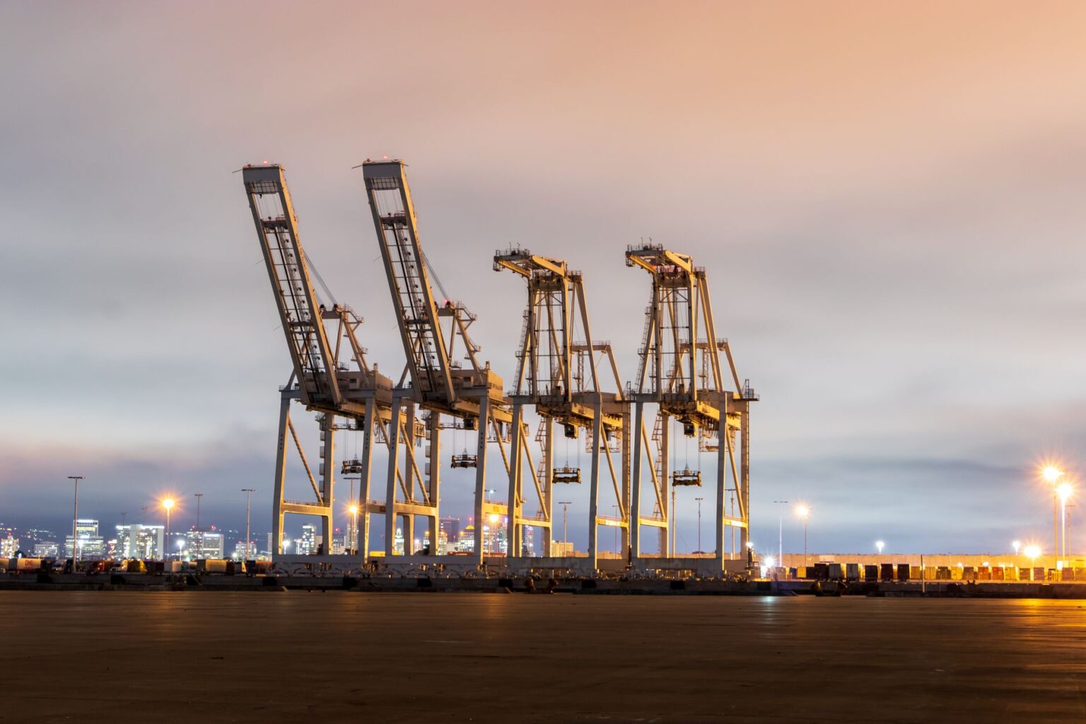 Longshoreman Automation Deals Stall as Port Labor Contracts Expire Large container port cranes unloading cargo ships at a busy terminal