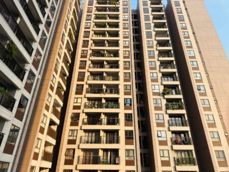 Exterior view of a multi-story apartment building representing affordable housing challenges in urban areas