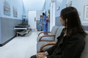 Patients sitting in a hospital waiting room, representing people affected by Medicaid coverage loss