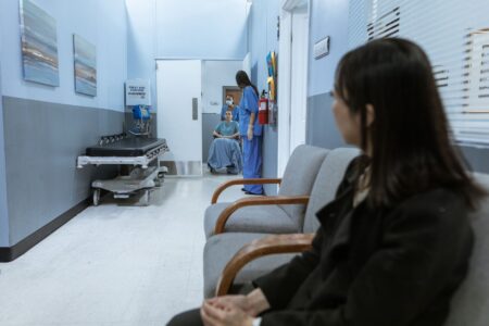 Patients sitting in a hospital waiting room, representing people affected by Medicaid coverage loss